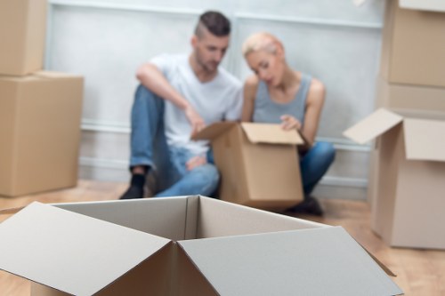 Moving team handling boxes and furniture in Holland Park