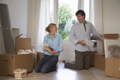 Local movers handling furniture in a West London residential street