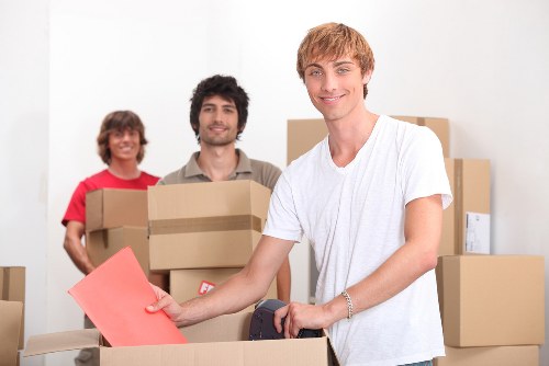 Movers transporting business equipment through a Holland Park property