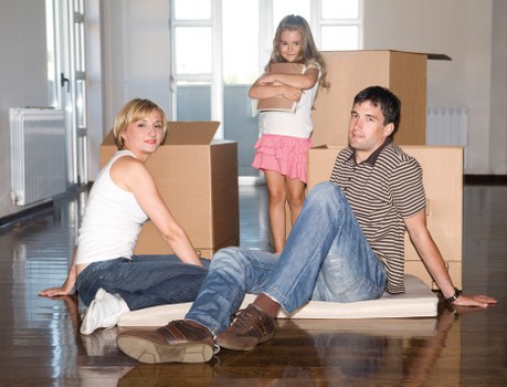 Removals crew carrying furniture through a Holland Park property